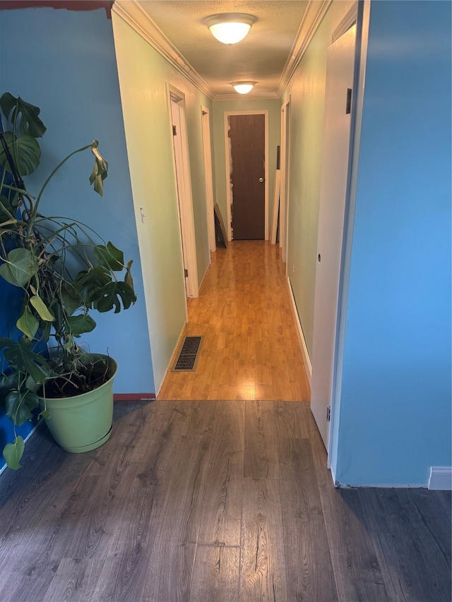 hall featuring hardwood / wood-style floors, a textured ceiling, and ornamental molding