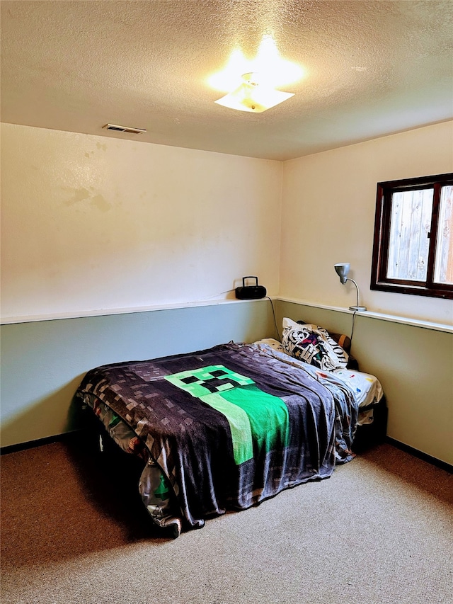 carpeted bedroom with a textured ceiling