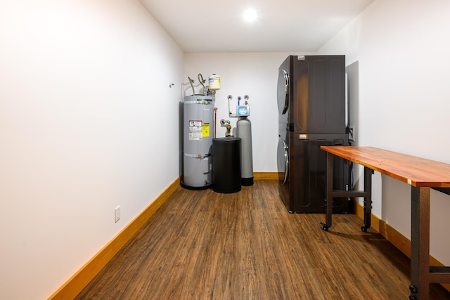 interior space with water heater, stacked washing maching and dryer, and dark hardwood / wood-style flooring