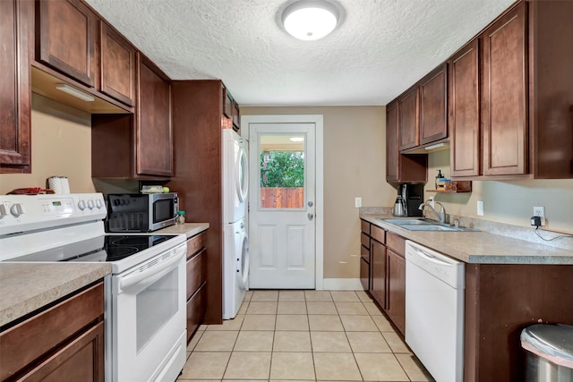 kitchen featuring a textured ceiling, white appliances, light tile patterned flooring, and sink