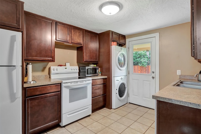 kitchen with stacked washer / dryer, white appliances, sink, and light tile patterned floors