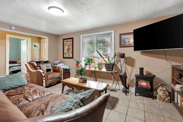 living room with a textured ceiling, light tile patterned flooring, and a wood stove