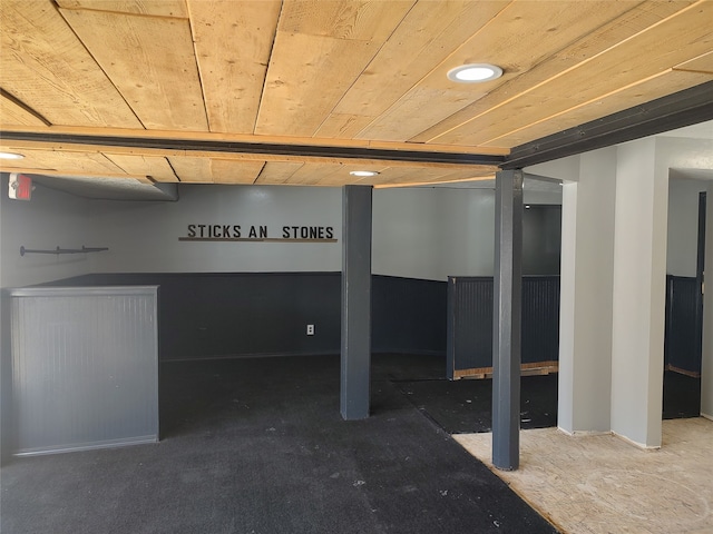 basement with wood ceiling and dark colored carpet