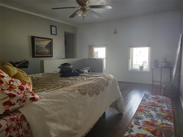 bedroom with ceiling fan, ornamental molding, and dark wood-type flooring