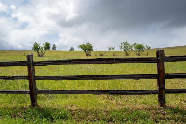 view of gate featuring a rural view and a yard