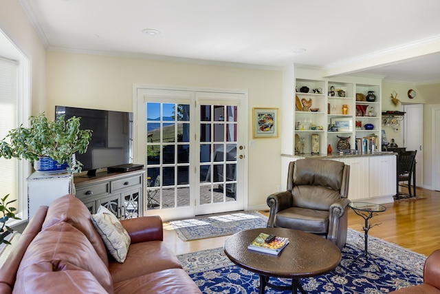 living room with light hardwood / wood-style floors and crown molding