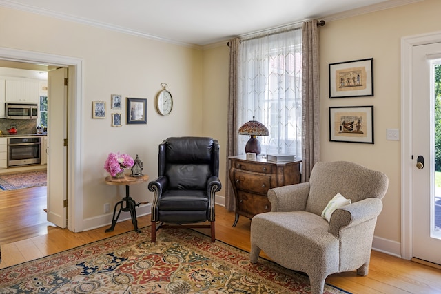 sitting room featuring crown molding and light hardwood / wood-style flooring