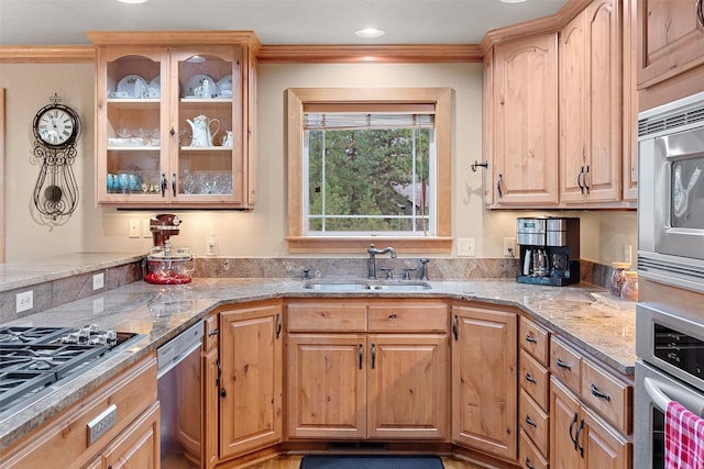 kitchen featuring ornamental molding, stainless steel appliances, light stone countertops, and sink