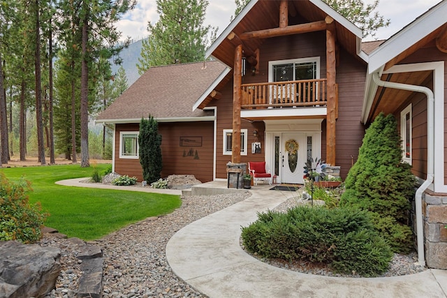 view of front of house with a front yard and a balcony