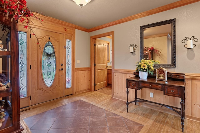 entryway with hardwood / wood-style flooring and crown molding