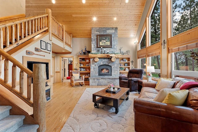 living room with wood ceiling, a fireplace, light hardwood / wood-style floors, and high vaulted ceiling