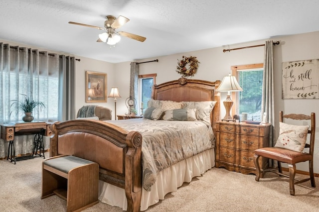 carpeted bedroom featuring ceiling fan, a textured ceiling, and multiple windows