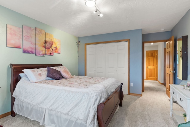 carpeted bedroom featuring a textured ceiling and a closet