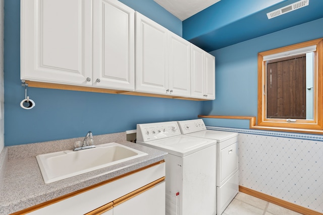 laundry area with sink, independent washer and dryer, and cabinets