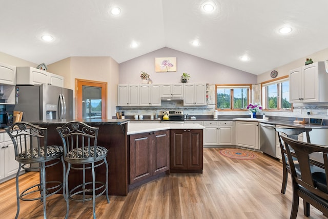 kitchen with appliances with stainless steel finishes, a center island, light hardwood / wood-style flooring, and white cabinets