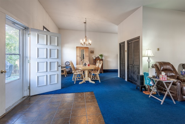 entrance foyer with a chandelier and dark carpet