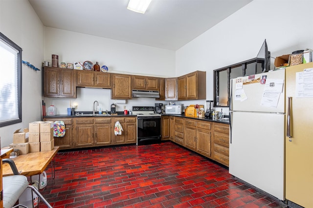 3938 US Highway 93 N, Stevensville, MT 59870 - kitchen with under cabinet range hood, white appliances, a sink, and dark countertops