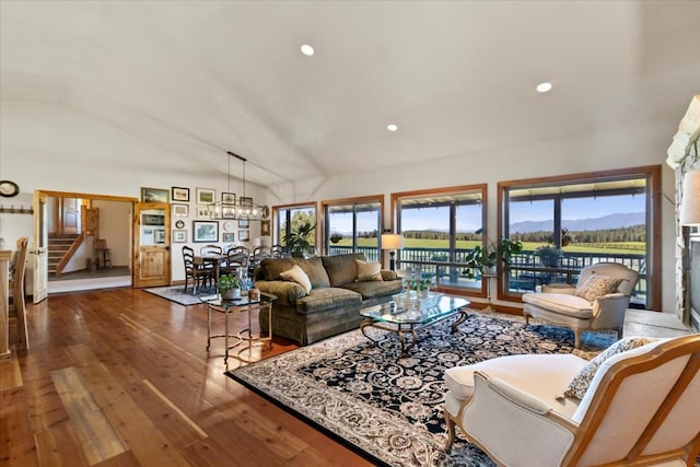 living room with hardwood / wood-style flooring, a notable chandelier, a mountain view, and lofted ceiling