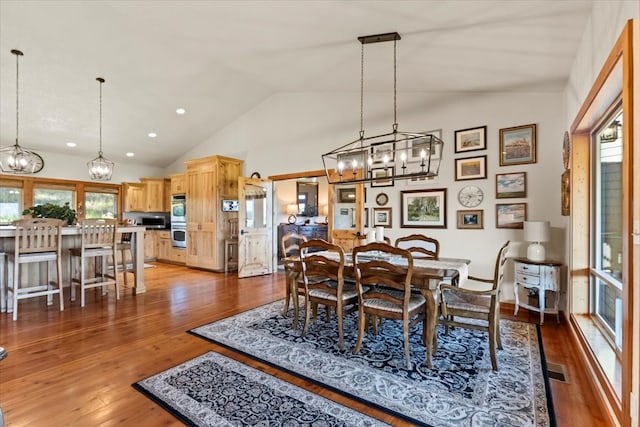 dining room featuring dark hardwood / wood-style flooring and vaulted ceiling