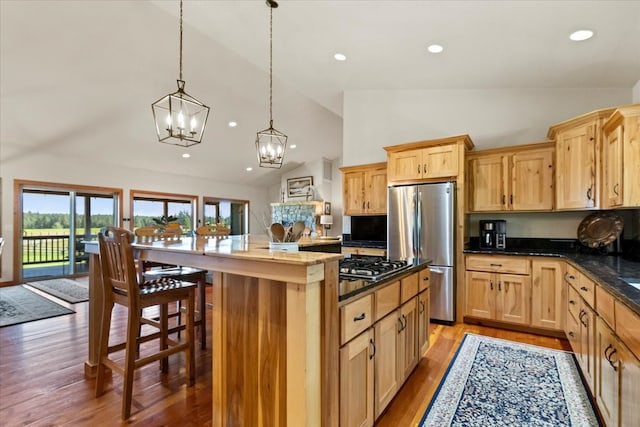 kitchen featuring stainless steel appliances, pendant lighting, a chandelier, light hardwood / wood-style floors, and a kitchen island