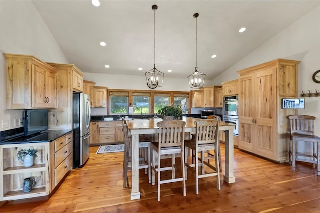 kitchen with stainless steel appliances, light hardwood / wood-style flooring, pendant lighting, a breakfast bar, and a kitchen island