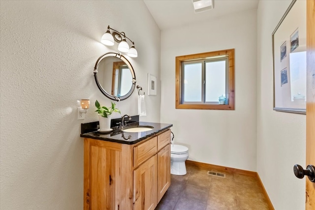 bathroom featuring tile patterned flooring, vanity, and toilet