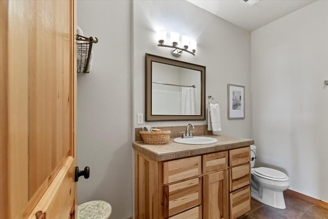 bathroom featuring tile patterned flooring, vanity, and toilet