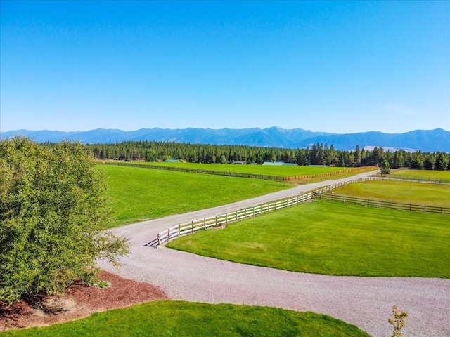 view of property's community featuring a lawn, a mountain view, and a rural view