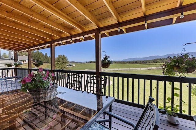 wooden deck with a lawn and a mountain view