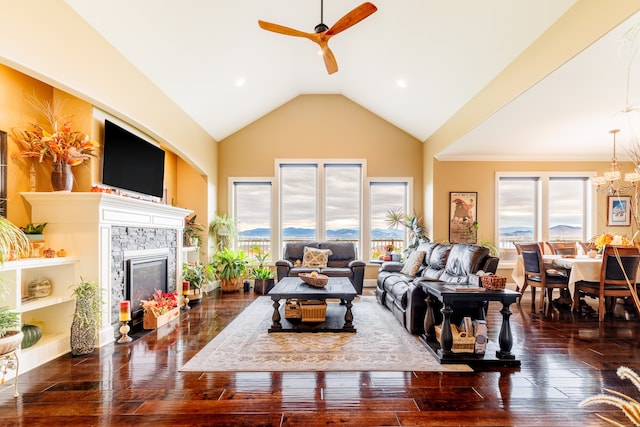 living room with ceiling fan with notable chandelier, dark wood-type flooring, and high vaulted ceiling