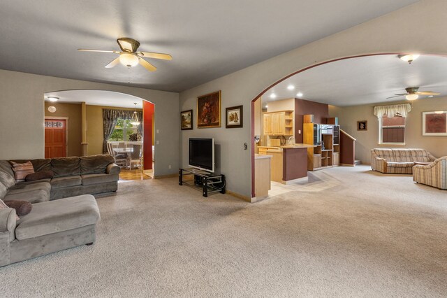 carpeted living room with ceiling fan