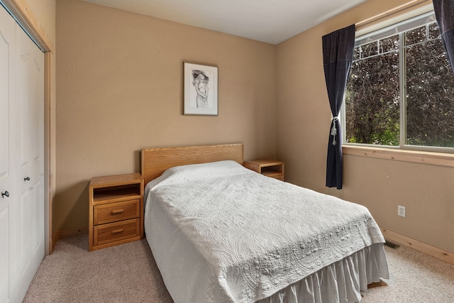 bedroom with light carpet and a closet