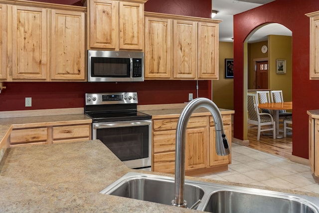 kitchen featuring light brown cabinets, sink, light hardwood / wood-style flooring, and stainless steel appliances