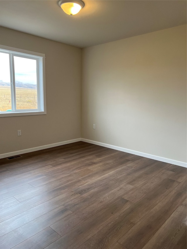 spare room with dark hardwood / wood-style flooring