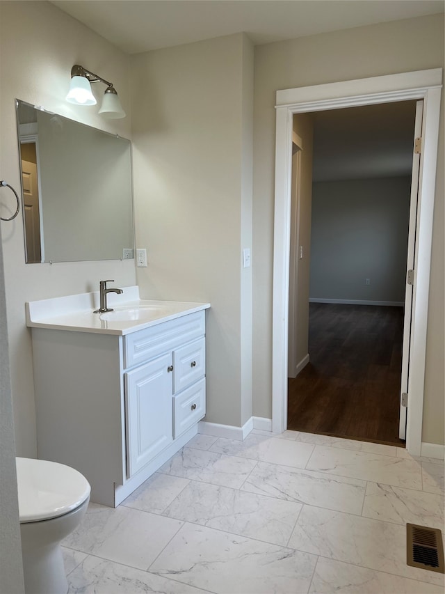 bathroom featuring vanity, hardwood / wood-style flooring, and toilet