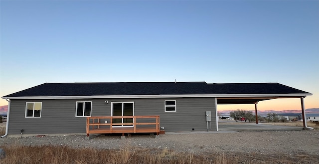 back house at dusk featuring a deck