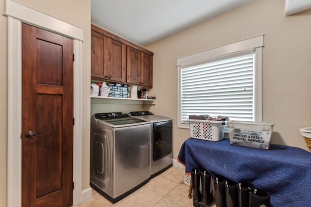 laundry area featuring cabinets, independent washer and dryer, and light tile patterned floors