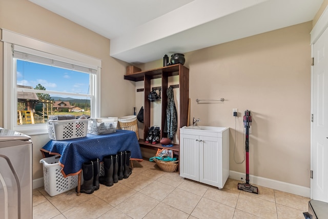 clothes washing area with sink and light tile patterned floors