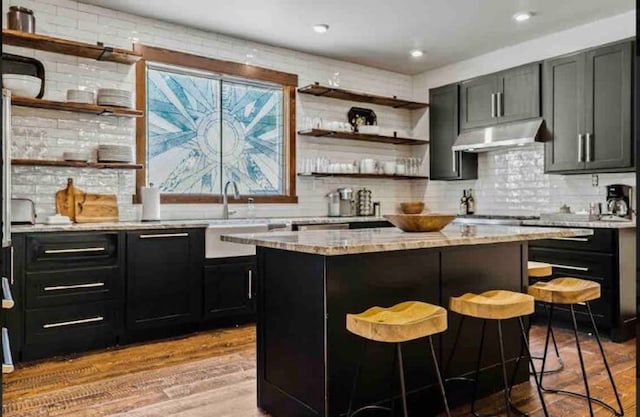 2870 US Highway 93 W, Whitefish, MT 59937 - kitchen with light hardwood / wood-style floors, decorative backsplash, and a kitchen bar