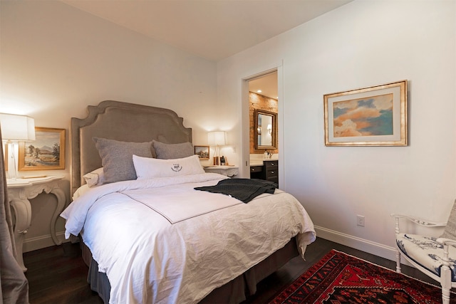 bedroom with connected bathroom and dark wood-type flooring