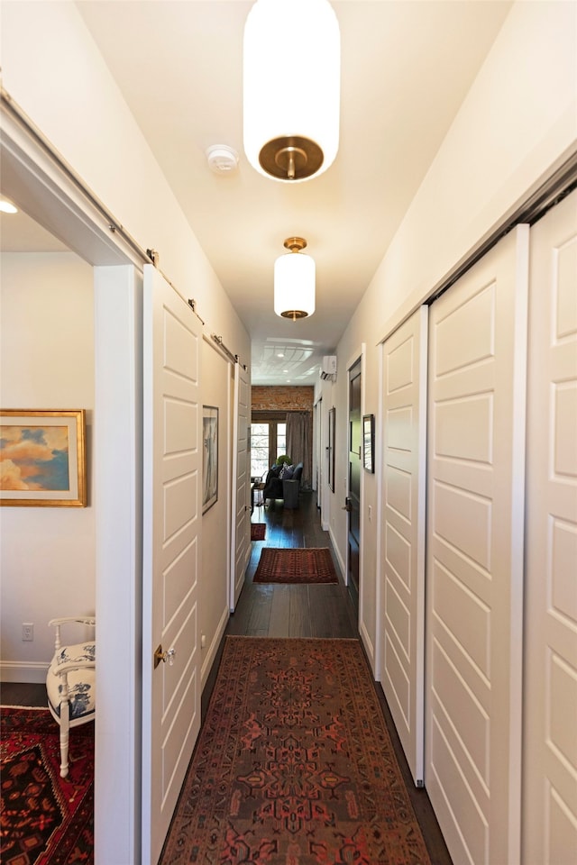 hall featuring a barn door and dark hardwood / wood-style flooring