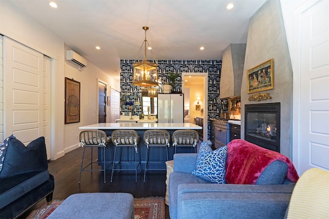 living room featuring a large fireplace, dark hardwood / wood-style floors, and a wall mounted air conditioner