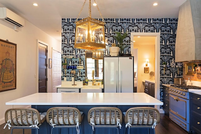 kitchen with appliances with stainless steel finishes, a wall mounted air conditioner, dark hardwood / wood-style flooring, and a kitchen island