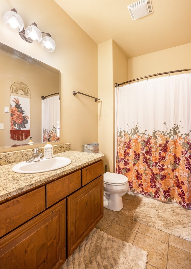 bathroom with curtained shower, vanity, toilet, and tile patterned floors