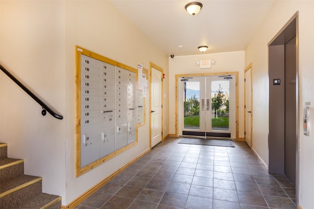 doorway to outside featuring dark tile patterned flooring, a mail area, and elevator