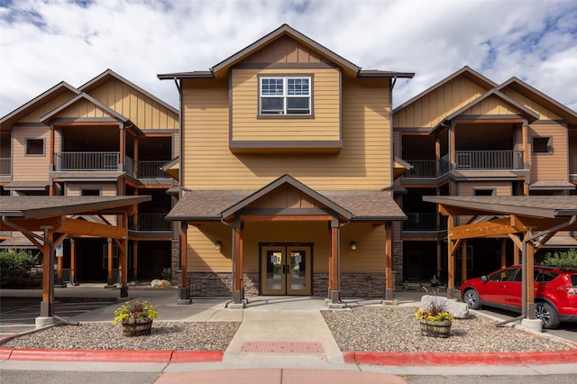 view of front of home featuring a balcony, a carport, and french doors