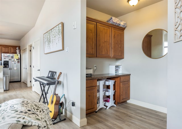 kitchen with light hardwood / wood-style flooring and stainless steel refrigerator with ice dispenser