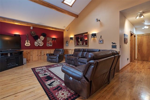 living room with high vaulted ceiling, wood walls, beamed ceiling, wood-type flooring, and a skylight