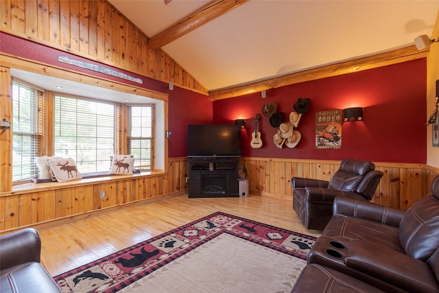 living room featuring wood walls, beam ceiling, hardwood / wood-style floors, and high vaulted ceiling