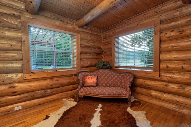 living area featuring wooden ceiling, beamed ceiling, rustic walls, and hardwood / wood-style flooring